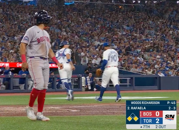 A Red Sox runner scores as the Blue Jays leave the field