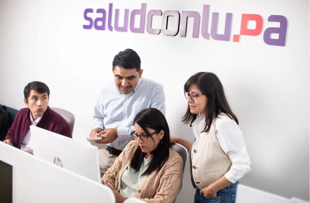 Journalists looking into a computer screen.