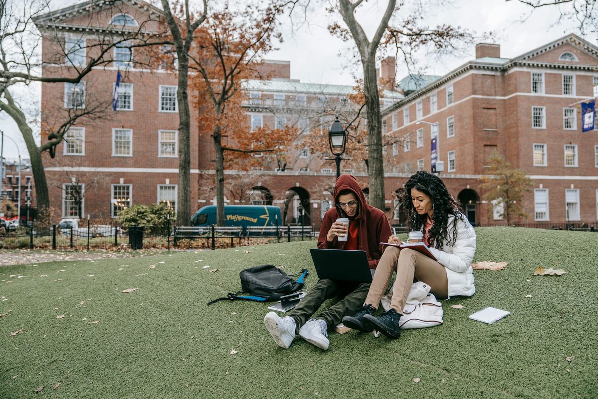 Man and woman studying outside on a college campus.