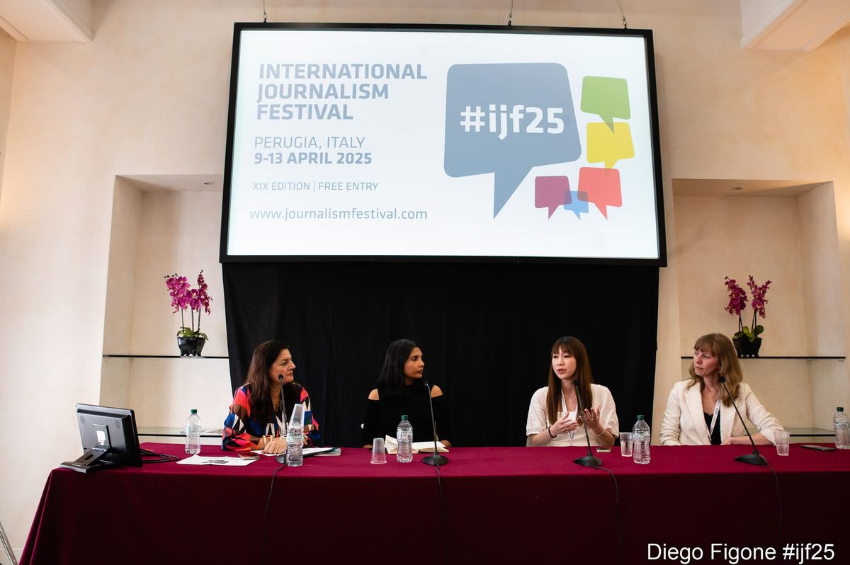 Panelists speaking in front of a screen.