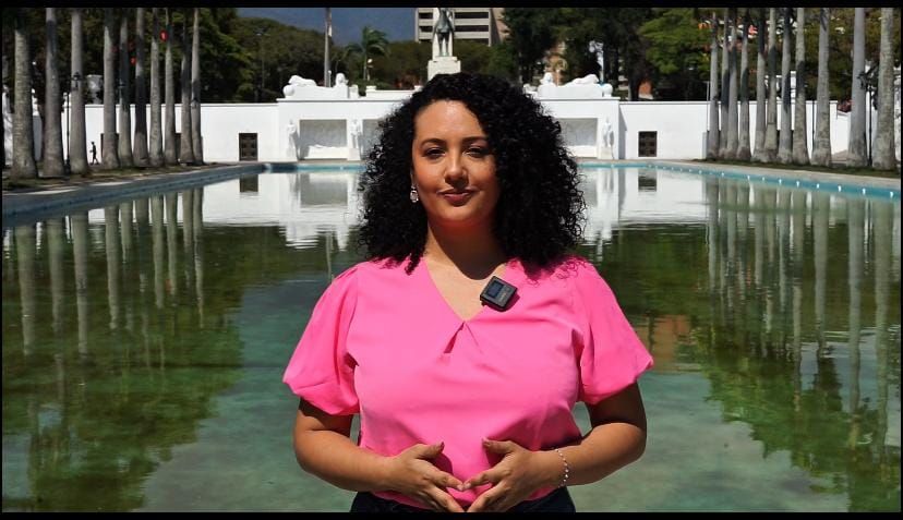 Ana standing in front of the camera wearing a pink shirt.