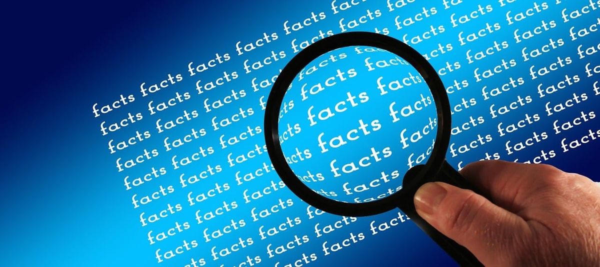 The word facts typed over and over again and a magnifying glass on top.