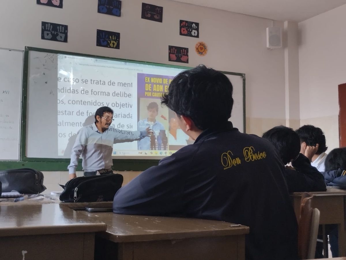 Gabriel standing in front of a white board as he talks to students.