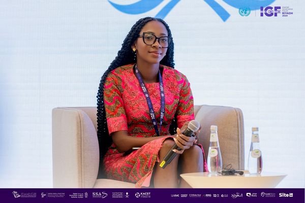 Jennifer sitting on a couch and holding microphone.