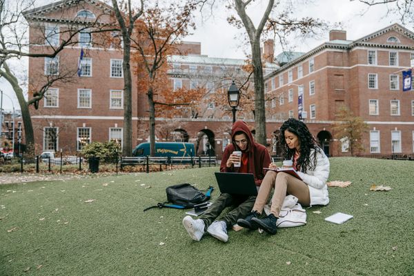 Man and woman studying outside on a college campus.