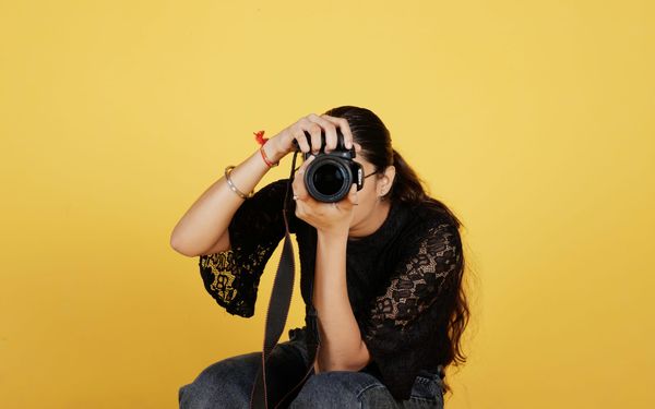 Femme photographe derrière son objectif