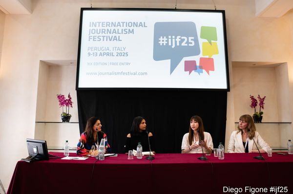 Panelists speaking in front of a screen.