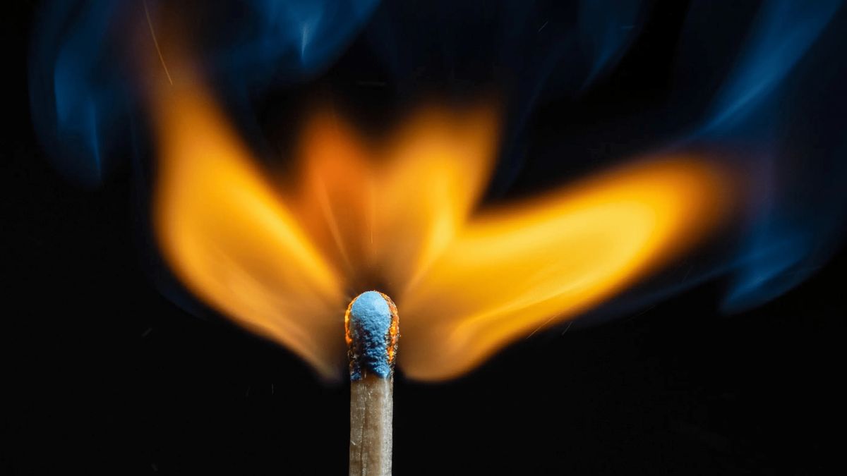 A lighted match against a dark background