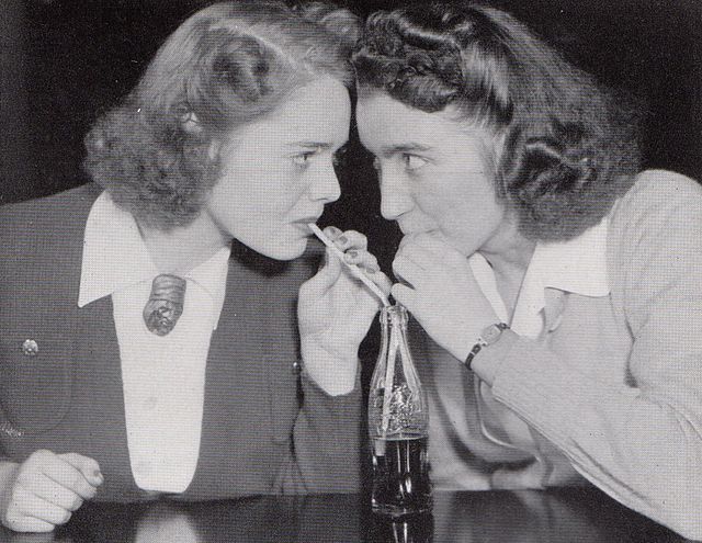 Photograph of two students sharing a bottle of Coca-Cola at Shimer College in 1941-1942, from the 1942 yearbook of Shimer Col