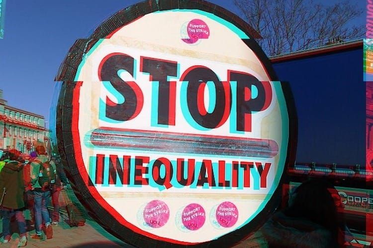 Artistic photograph of a round sign with 'Stop inequality' written on it with some UCU stickers. 