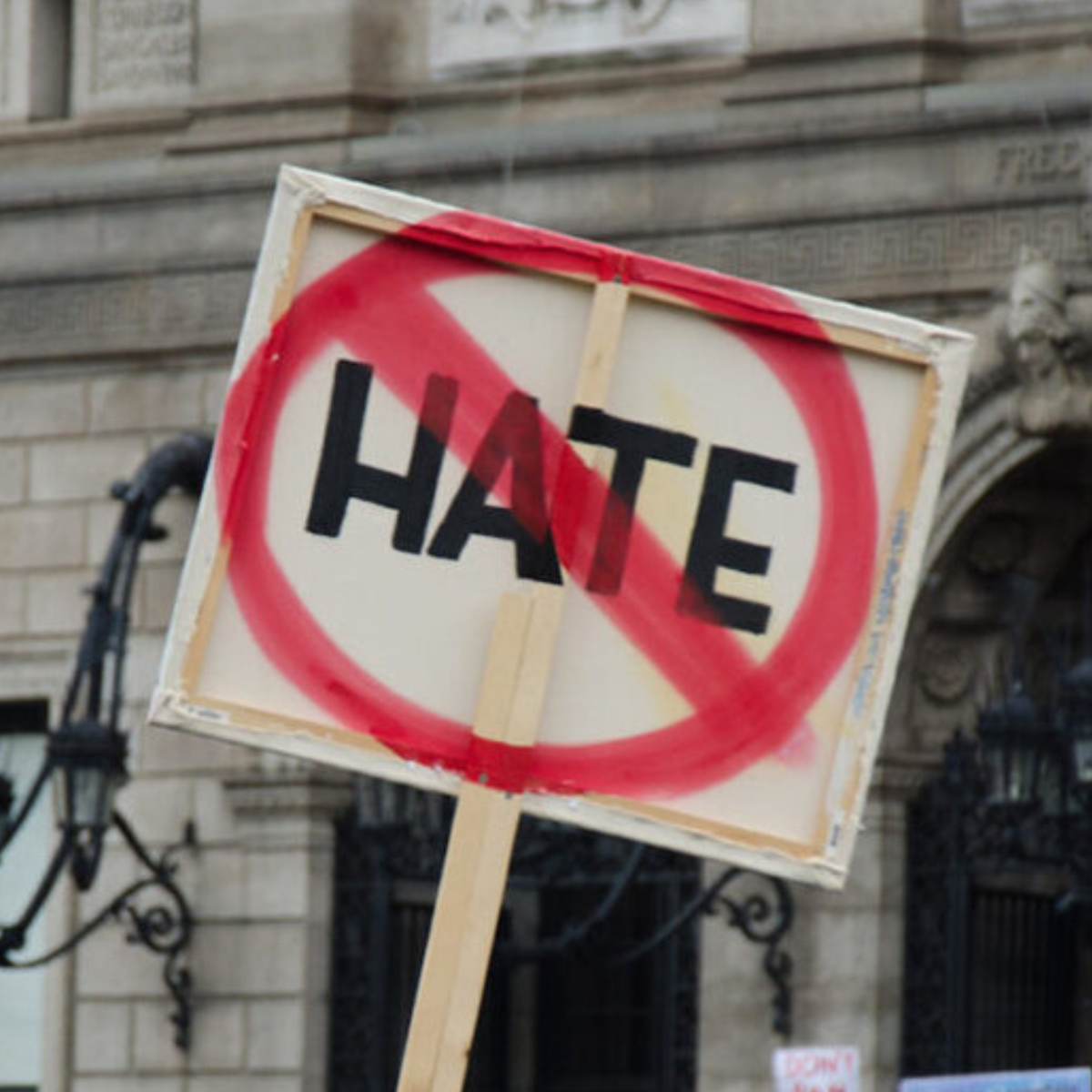 Back of protest sign with HATE crossed out with a red circle and diagonal.