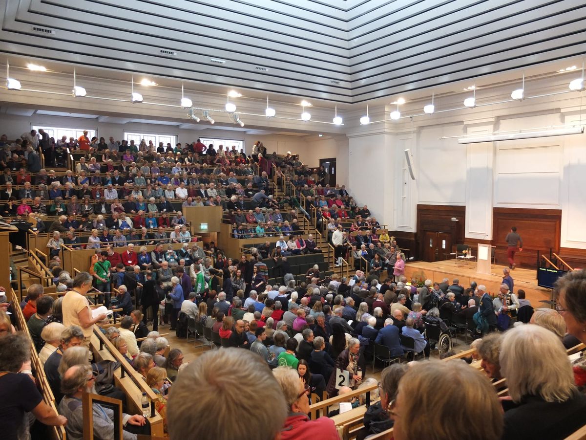 a photograph from the Quaker Annual Meeting showing delegates in a large conference hall