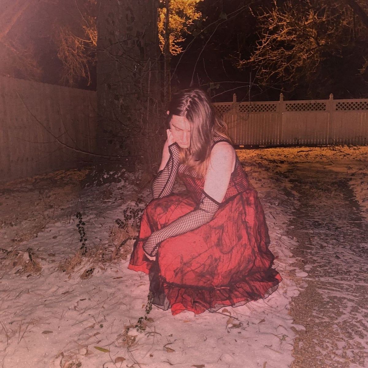 whit3corset in a red dress, outdoors in a light dusting of snow.