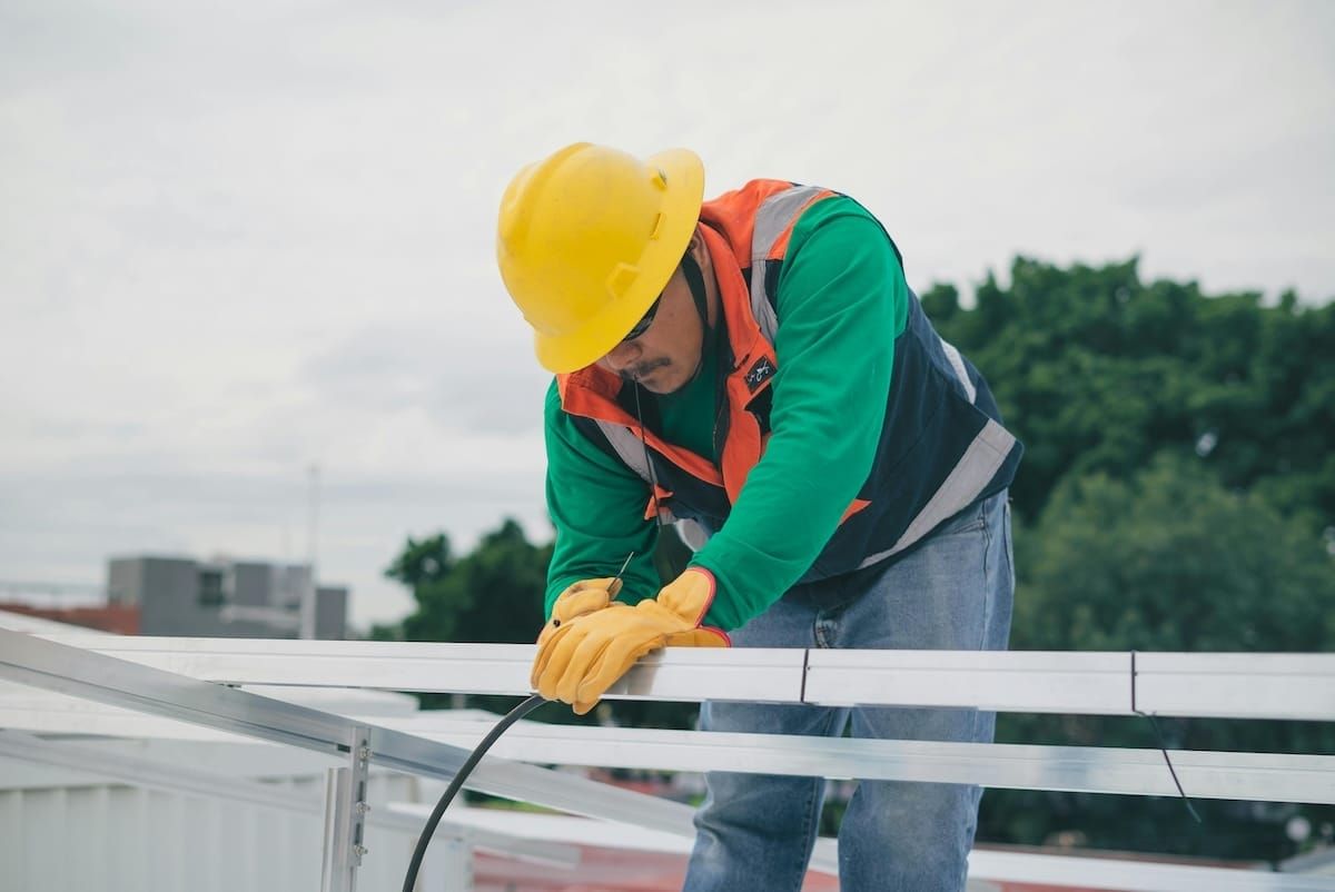 Man doing electrical work on a roof