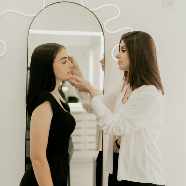 One woman applying makeup to another woman.