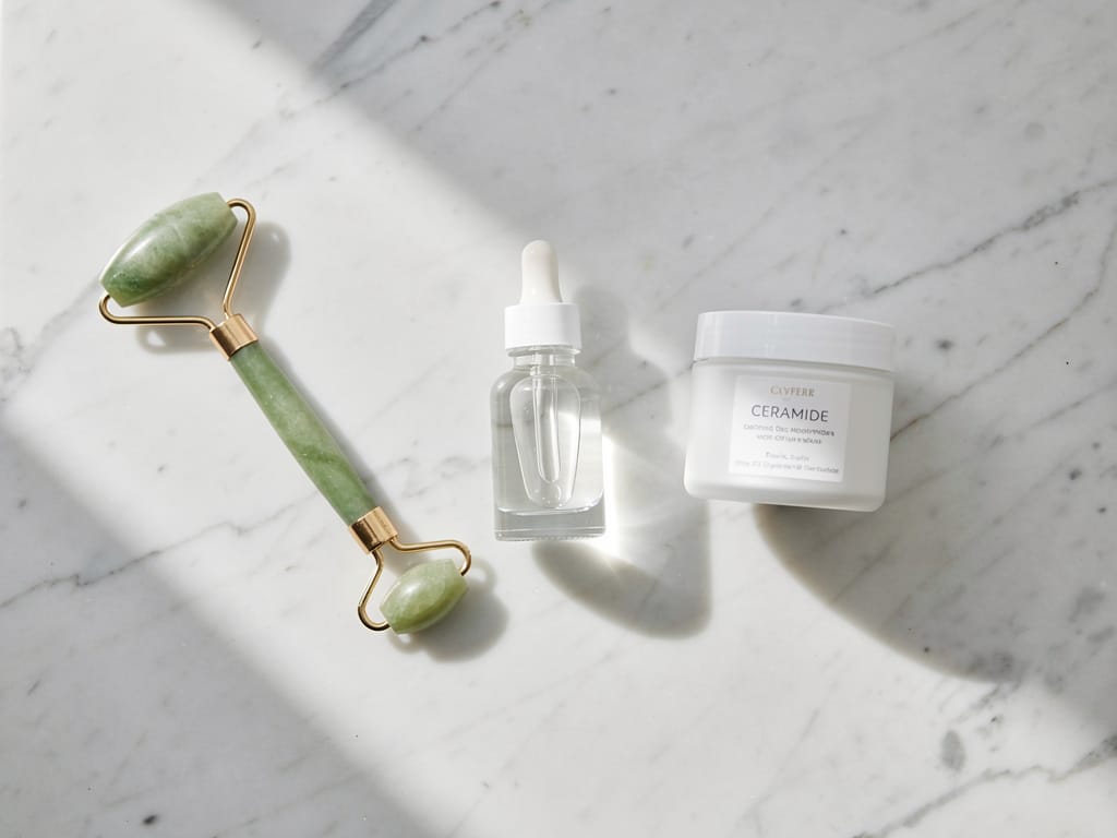 Minimalist skincare flat lay with serum and moisturizer on marble