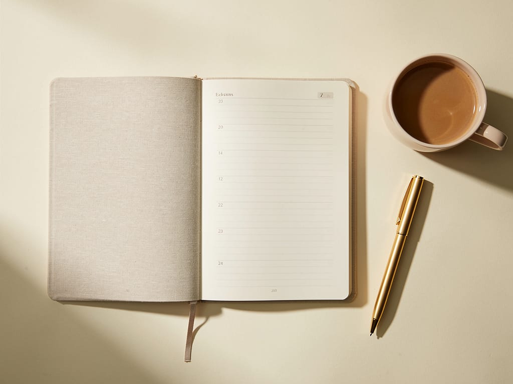 A planner and coffee mug on a desk representing strategic planning.