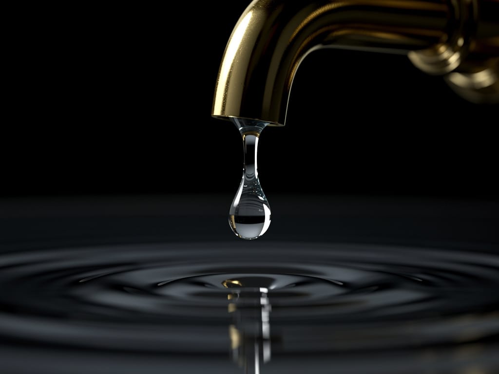 A single drop of water creating ripples in a still pool