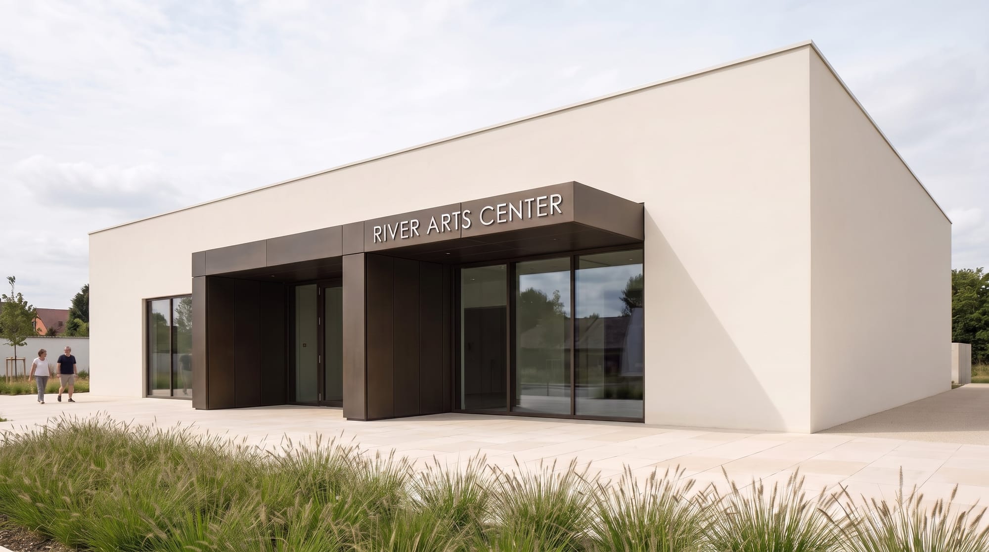 River Arts Center name installed in modest brushed aluminum letters on the dark bronze entrance canopy.