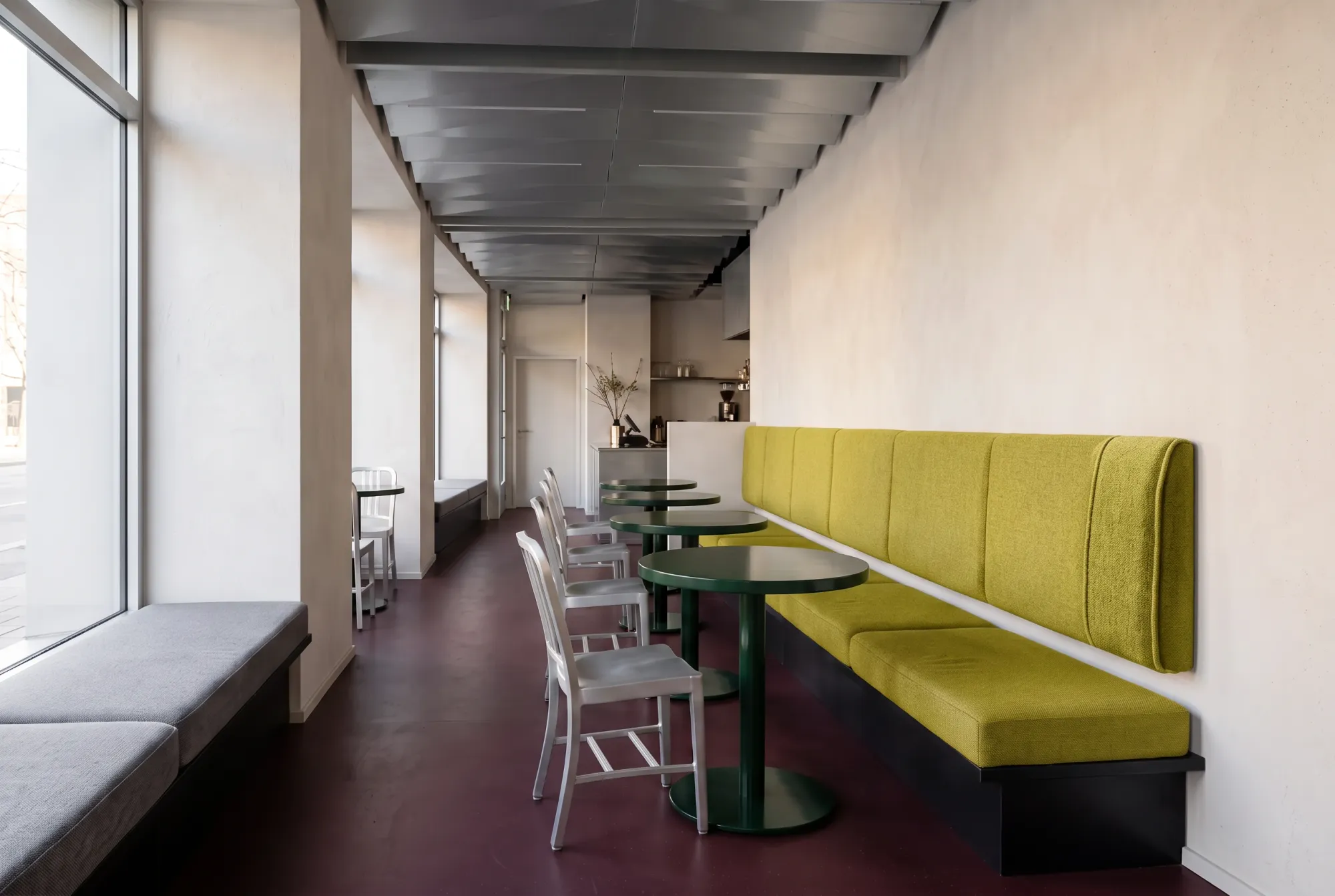 The right-hand banquette receives the chartreuse weave while the window seats remain grey.