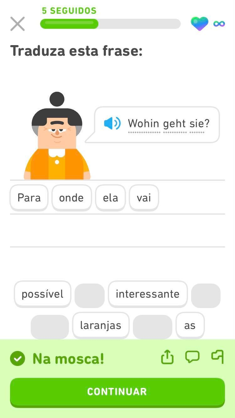 Captura de tela de um exercício com a pergunta em alemão “Wohin geht sie?”. Abaixo, os blocos de palavras em português dizem “Para onde ela vai?”. Depois, aparece a mensagem “Na mosca!”, seguida por um botão verde com a palavra “Continuar”.