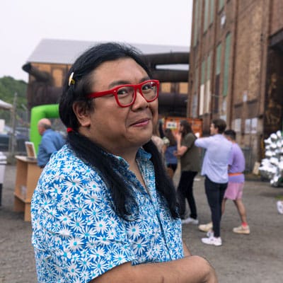 건물과 군중 앞에 서 있는 웃는 모습의 Duo 사진