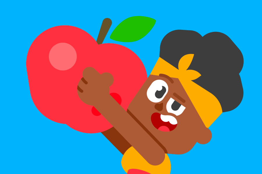 Bia segurando uma maçã grande e sorrindo.