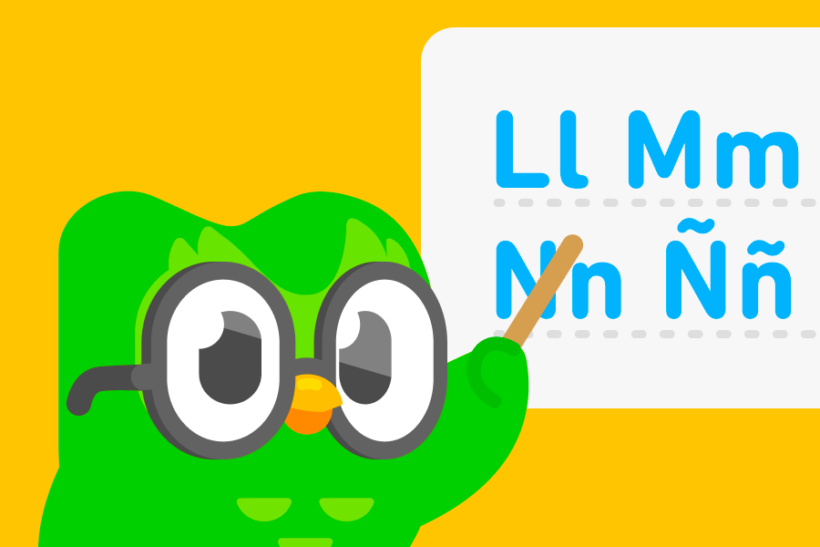 Duo le hibou porte des lunettes et pointe sur un tableau blanc les lettres L, M, N et Ñ de l’alphabet espagnol.
