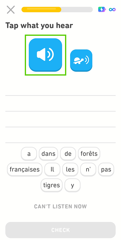 Screenshot of the app mid-lesson. The instructions given for the exercise are “Tap what you hear,” with a blank space and a word bank of French words beneath. There is a blue button with a speaker icon and a smaller blue button with an image of a turtle. The speaker button is highlighted in green.