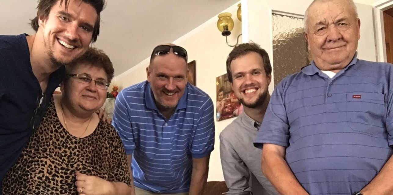 Mi hermano Joshua, mi tía Halina, mi papá, yo y mi tío Mietek sonriendo y posando para la cámara en su hogar.