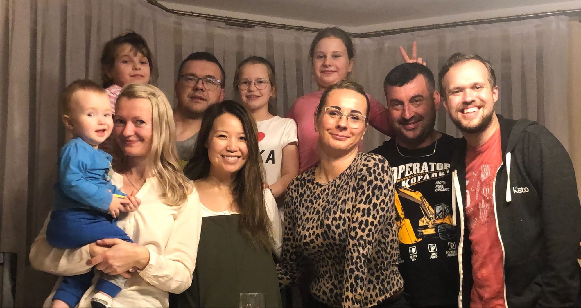 Z moimi kuzynami, Michałem i Grześkiem, ich żonami i dziećmi w domu Grześka. Uśmiechamy się do zdjęcia, a jego córka robi mu zajączka.
