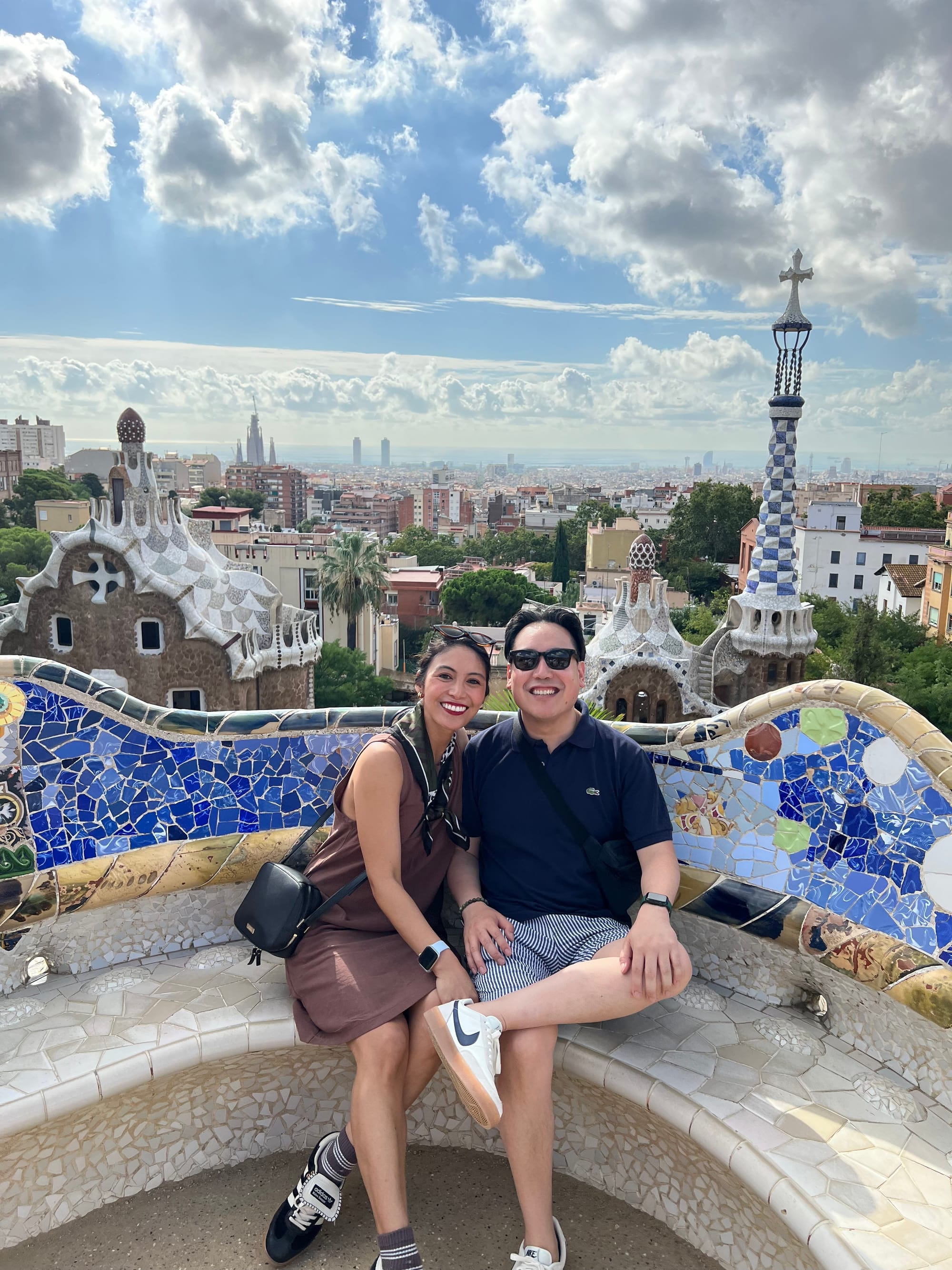 Photo of Alexa and Daryl sitting on a tiled bench at Park Güell in Barcelona, Spain.