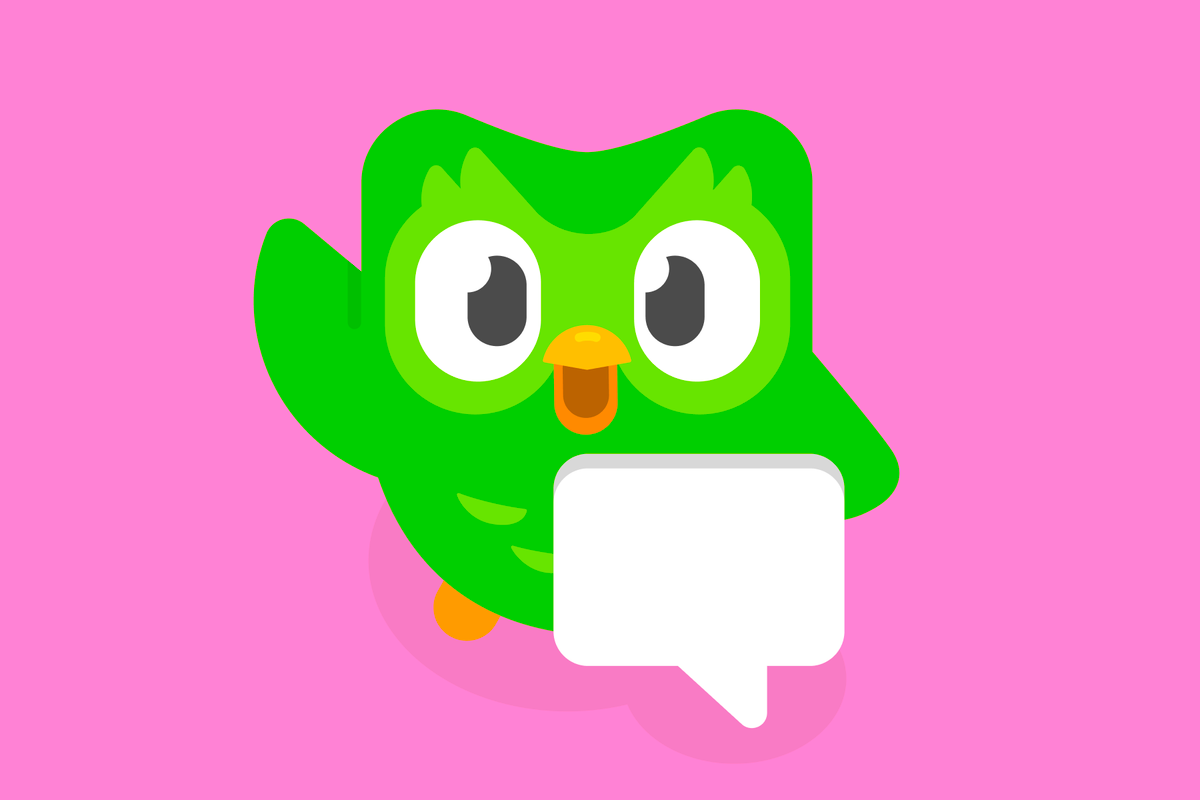 Duo the owl on a pink background, waving and standing behind a floating speech bubble