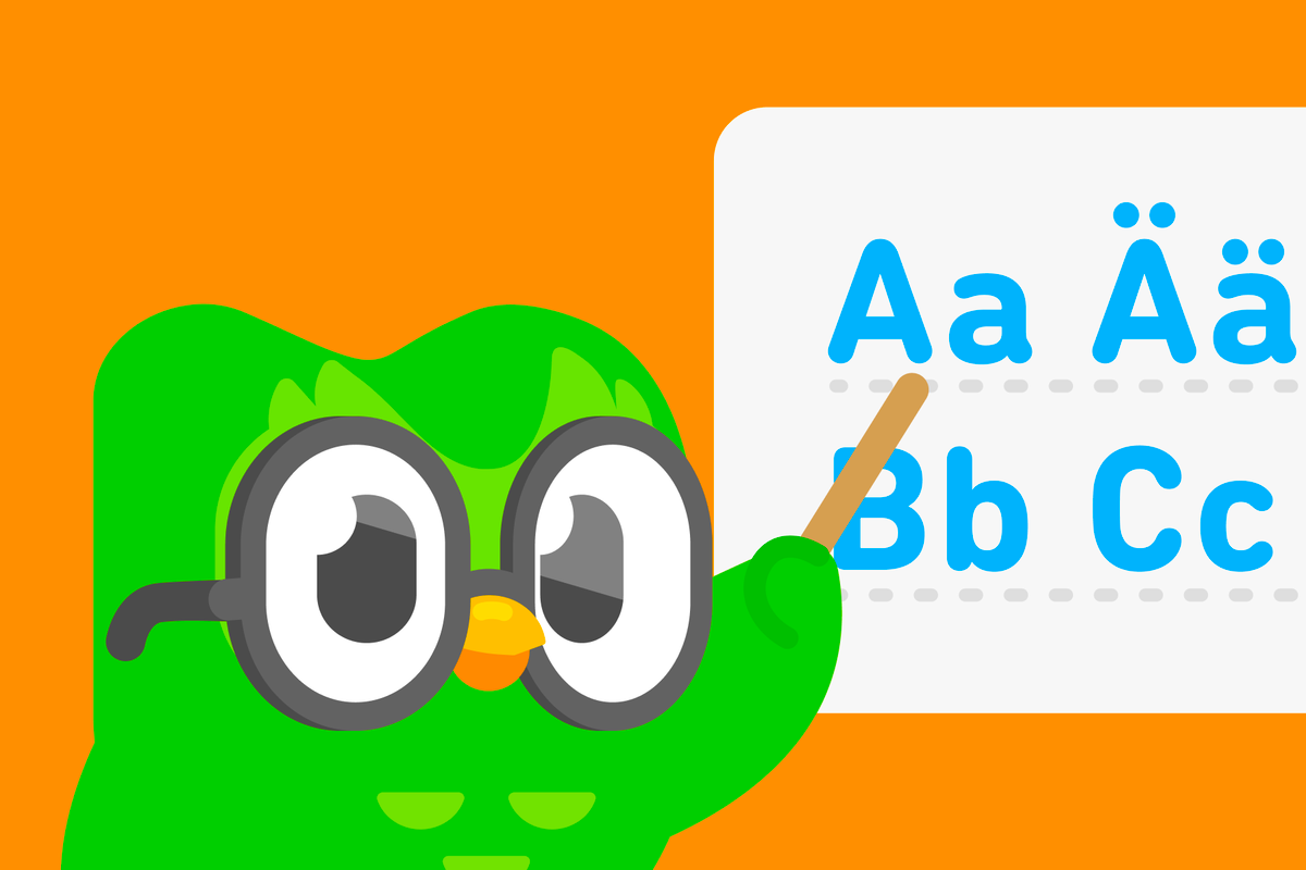 Duo de óculos apontando com uma varinha para as letras “A”, “Ä”, “B” e “C” do alfabeto em alemão, escritas em uma lousa.