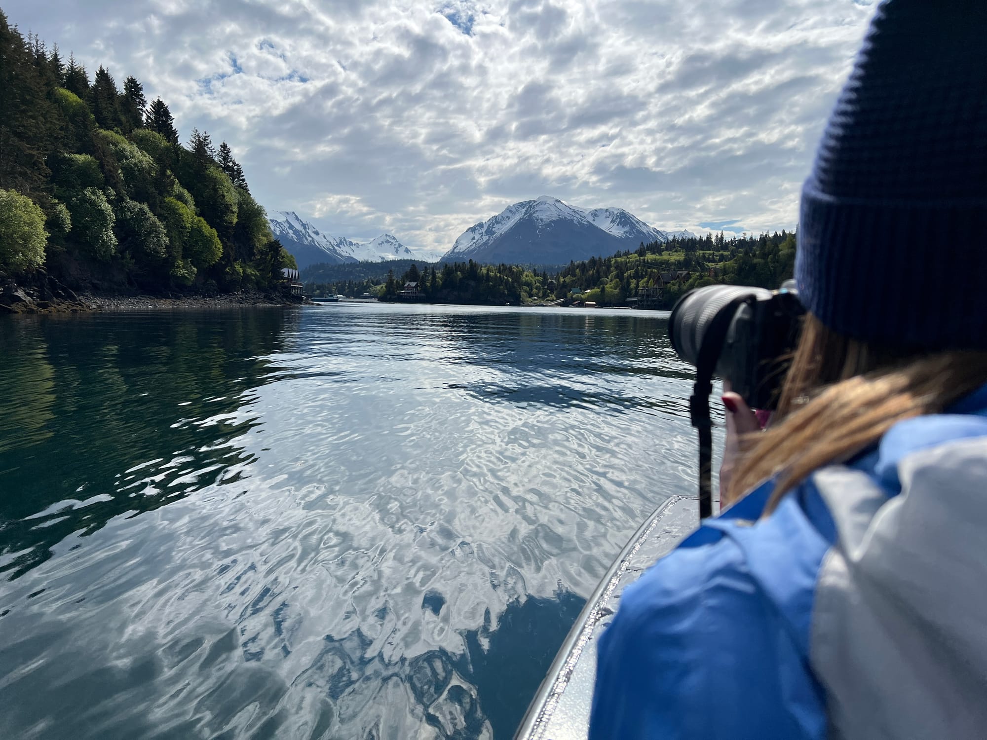 Photo over the shoulder of a photographer with water and mountains in the background