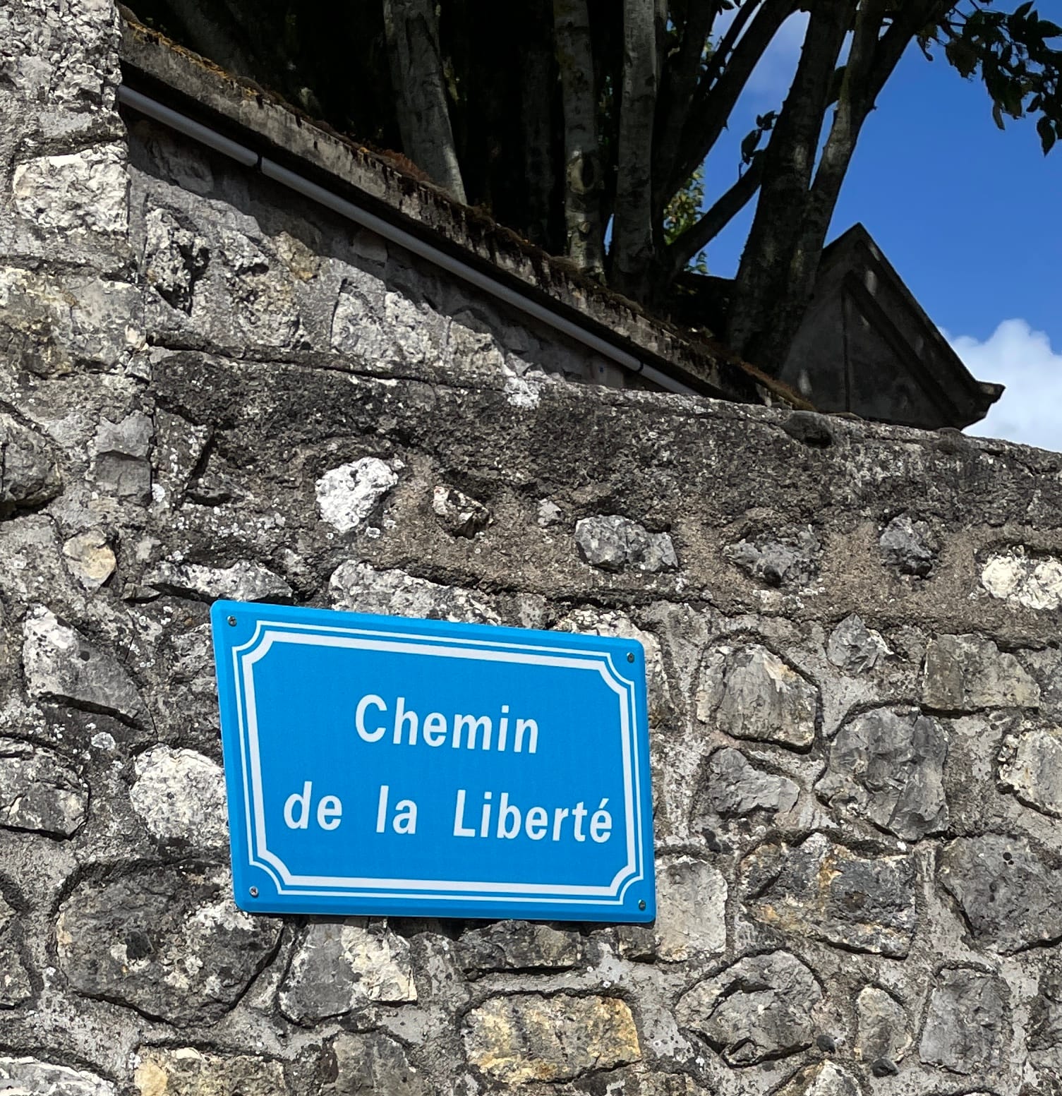 A picture of a French street name sign that reads: "Freedom Road".