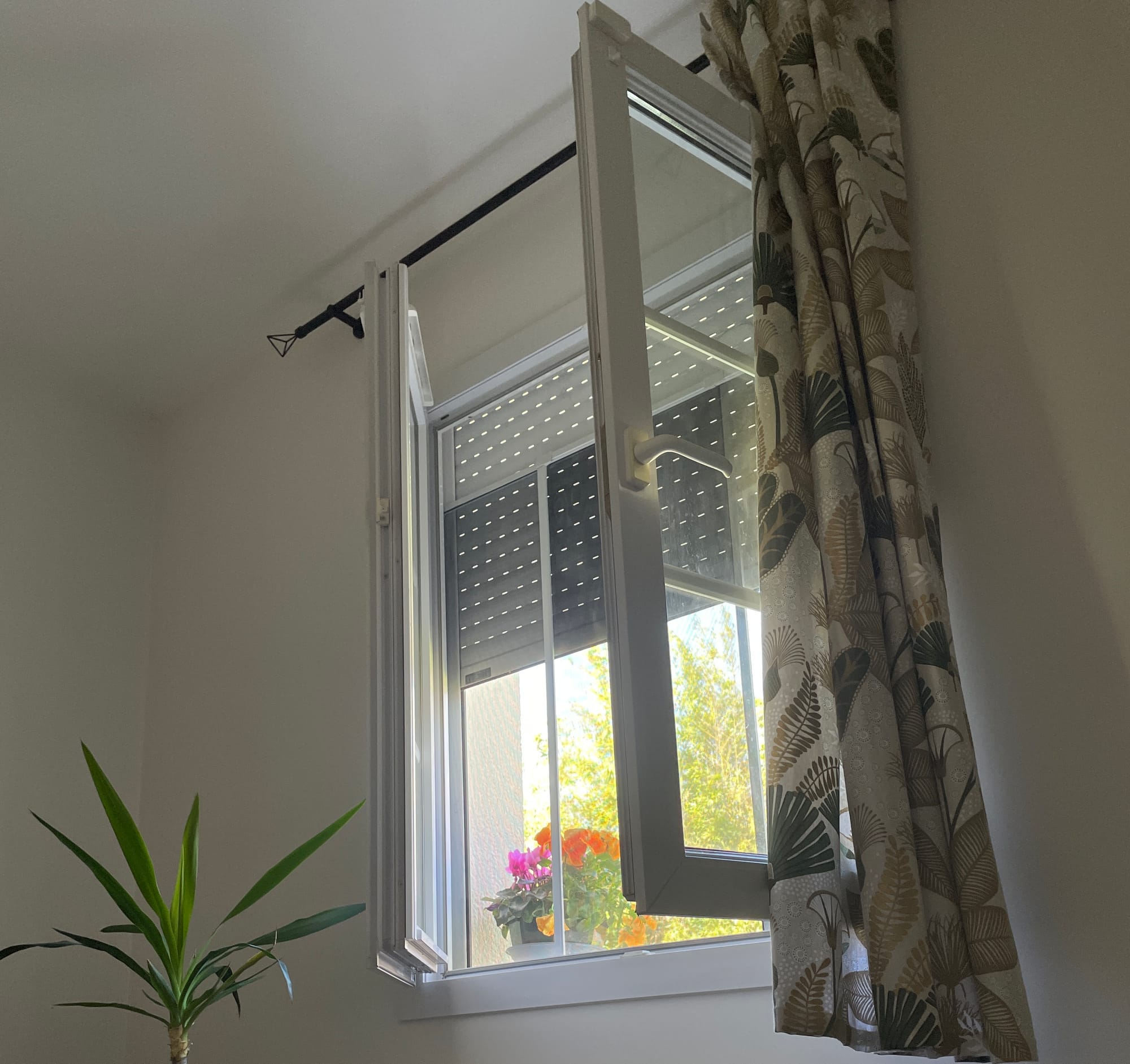 My window, with the shutter half open. Soft light filtering in from outside, and flowers on the sill.