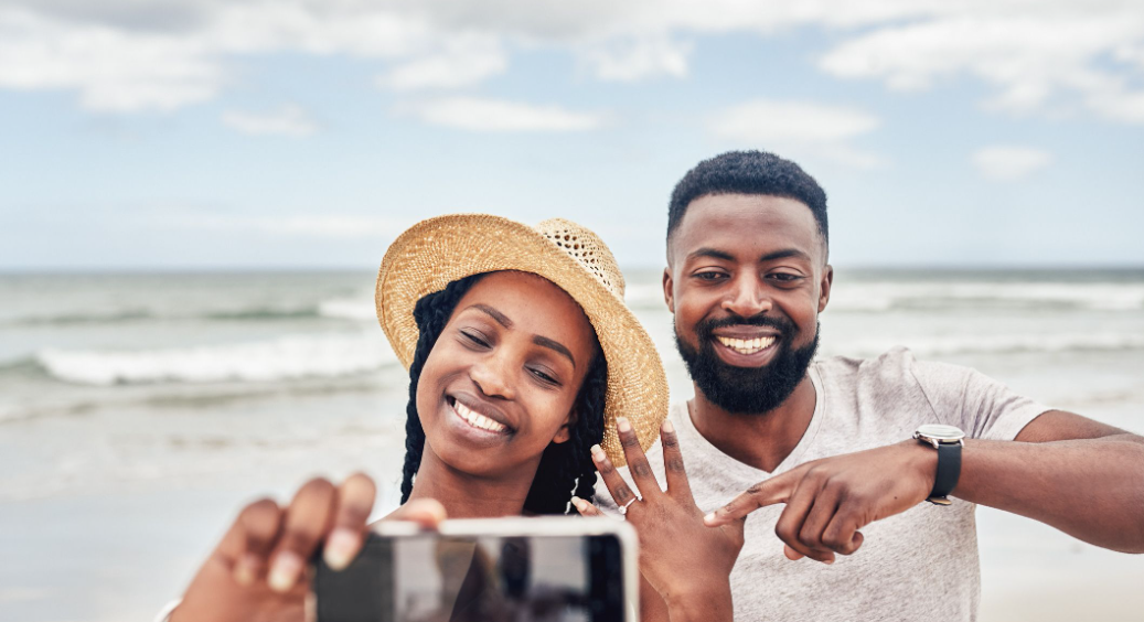 A woman wearing wedding rings and a man are taking a photo.
