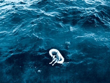 A person floats in an inflatable raft in the water.