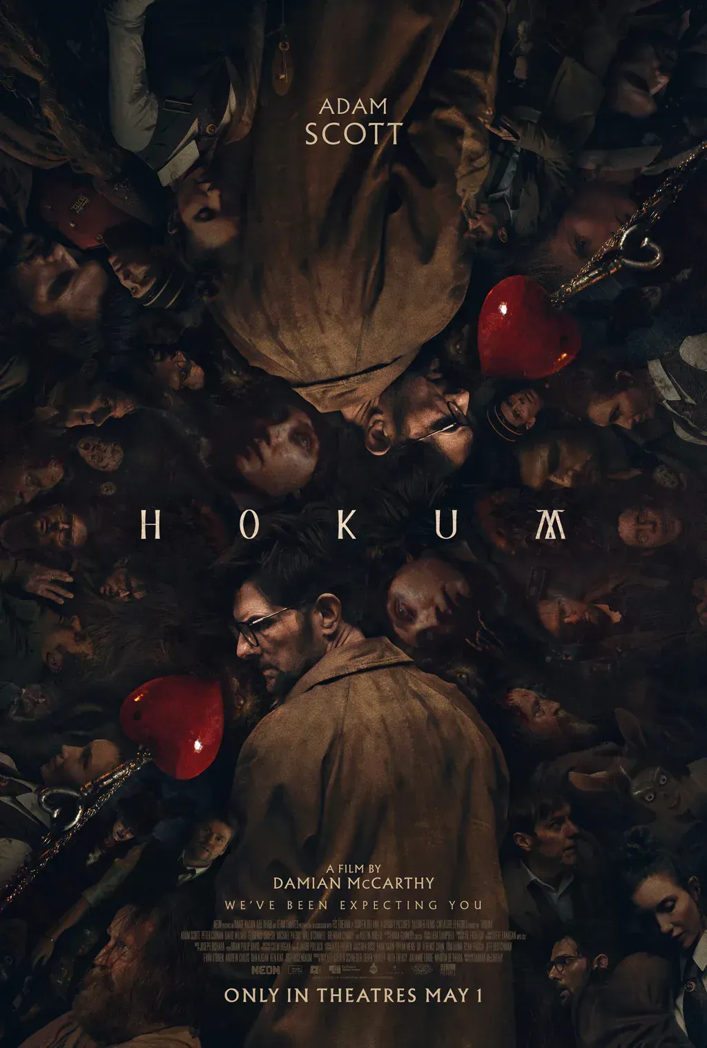 Hokum poster, featuring Ohm reflected vertically surrounded by the ensemble of characters in the film, two heart pendants and the text "HOKUM A film by Damian Mc Carthy We've Been Expecting Y