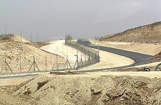 A fence and a cleared, desolate area 
