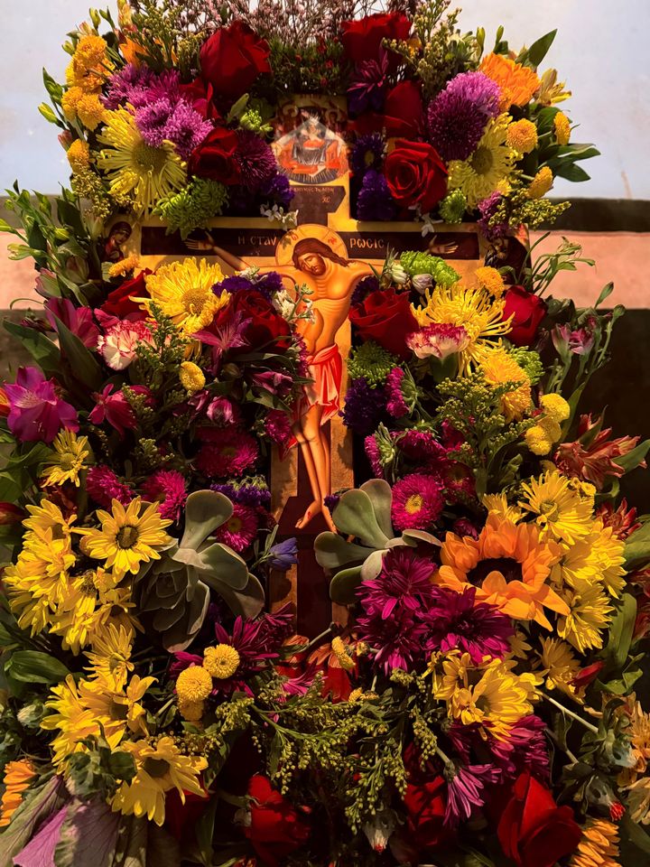 Orthodox Crucifix surrounded by colorful flowers.