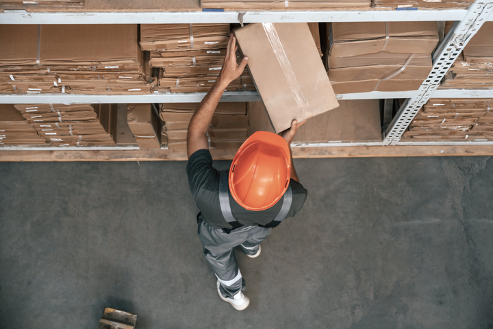 창고 선반에서 박스를 꺼내고 있는 직원