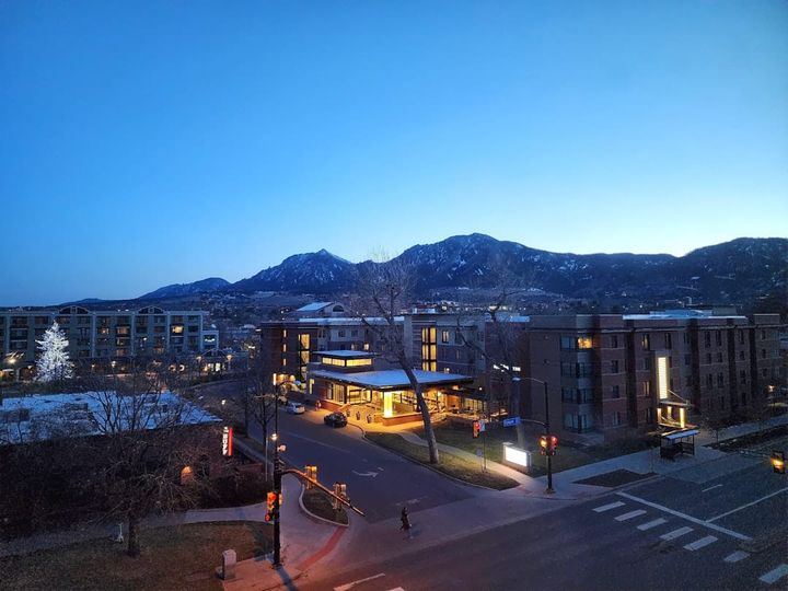 A Boulder, Colorado cityscape with the Front Range foothills rising behind the central city