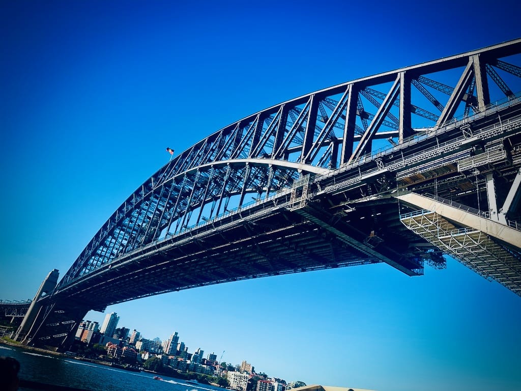 The steel arch of a bridge spanning a body of water