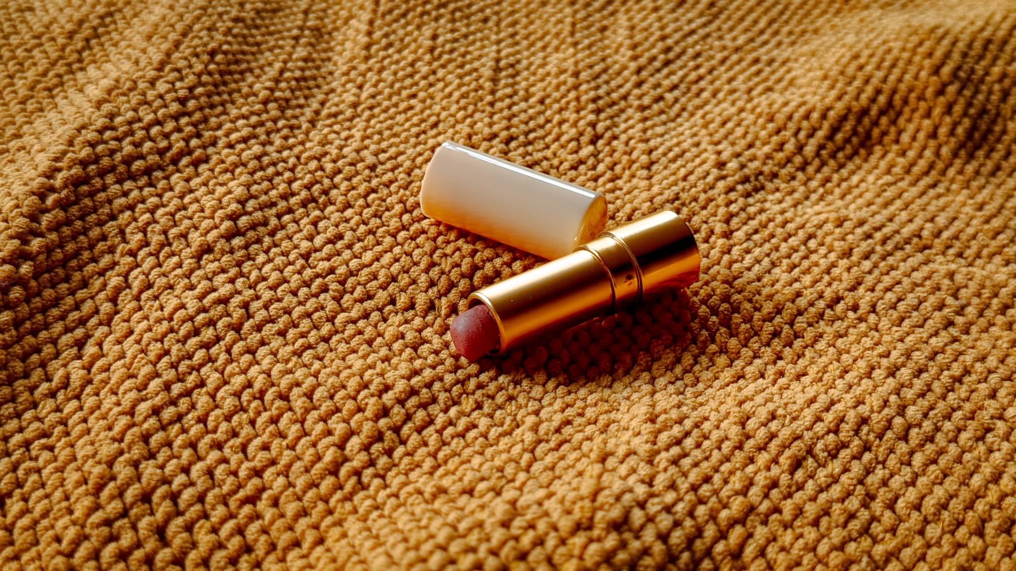 Gucci Rouge À Lèvres Matte Lipstick in They Met in Argentina mini size on warm-toned fabric