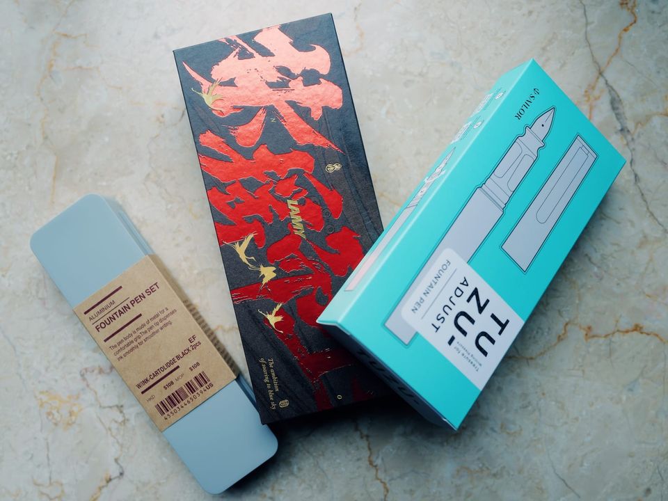 A picture of 3 boxed pens: Muji, LAMY, and Sailo