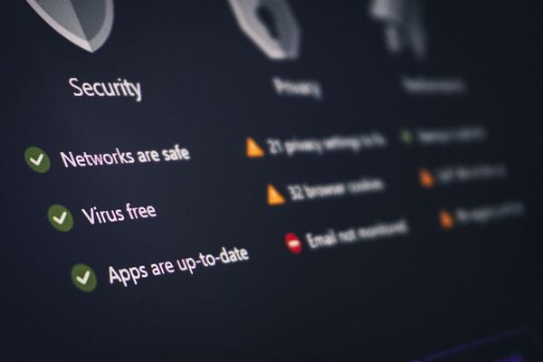 Person using laptop with digital security graphic overlay