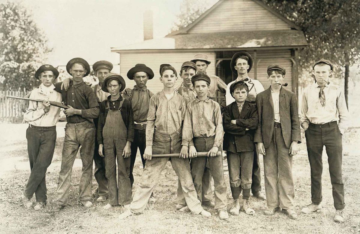 Old photo of rascals with baseball bat and rifle.
