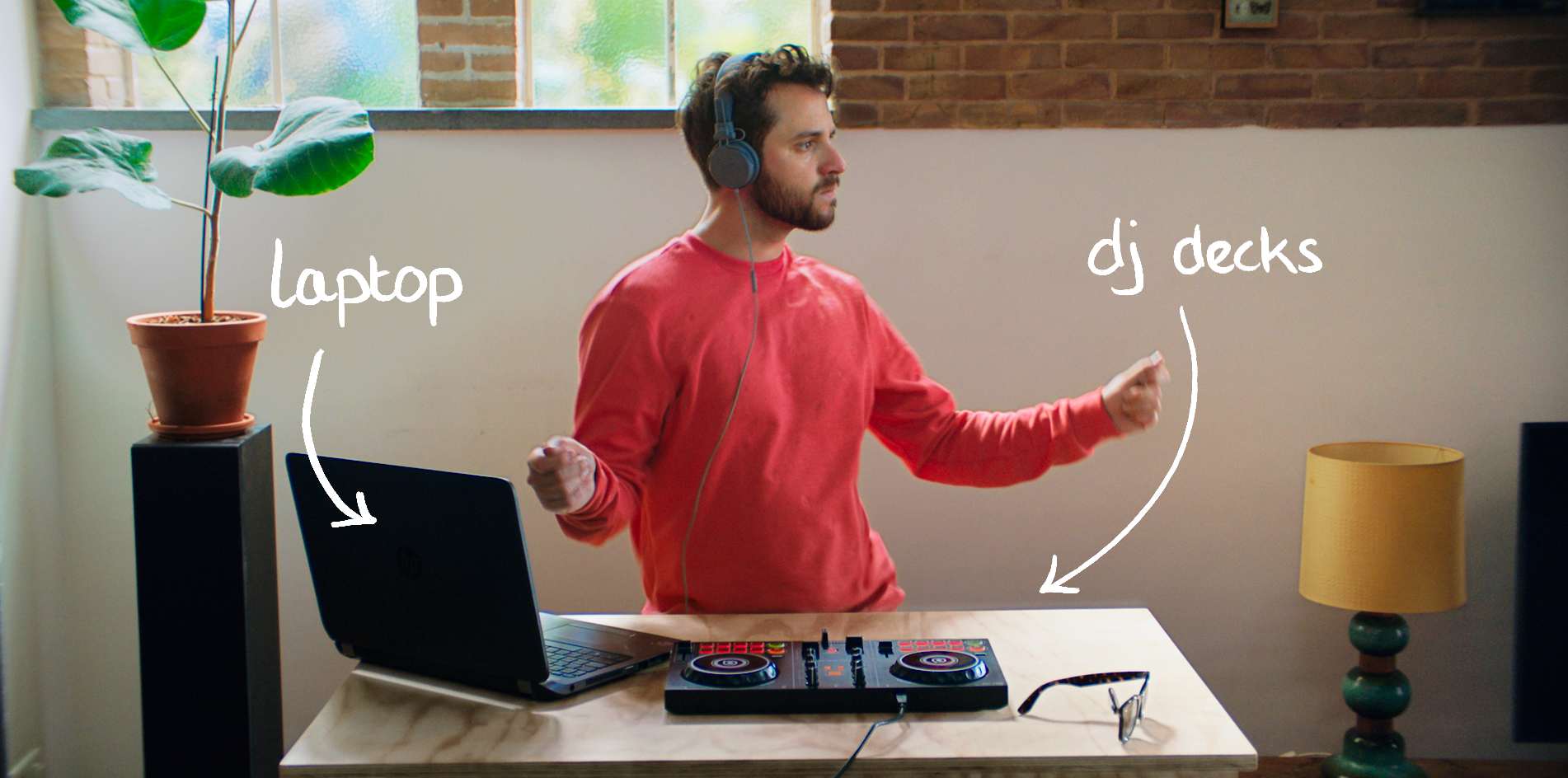 Urban-Jungle renter with his laptop and DJ-deck on a wooden coffee table